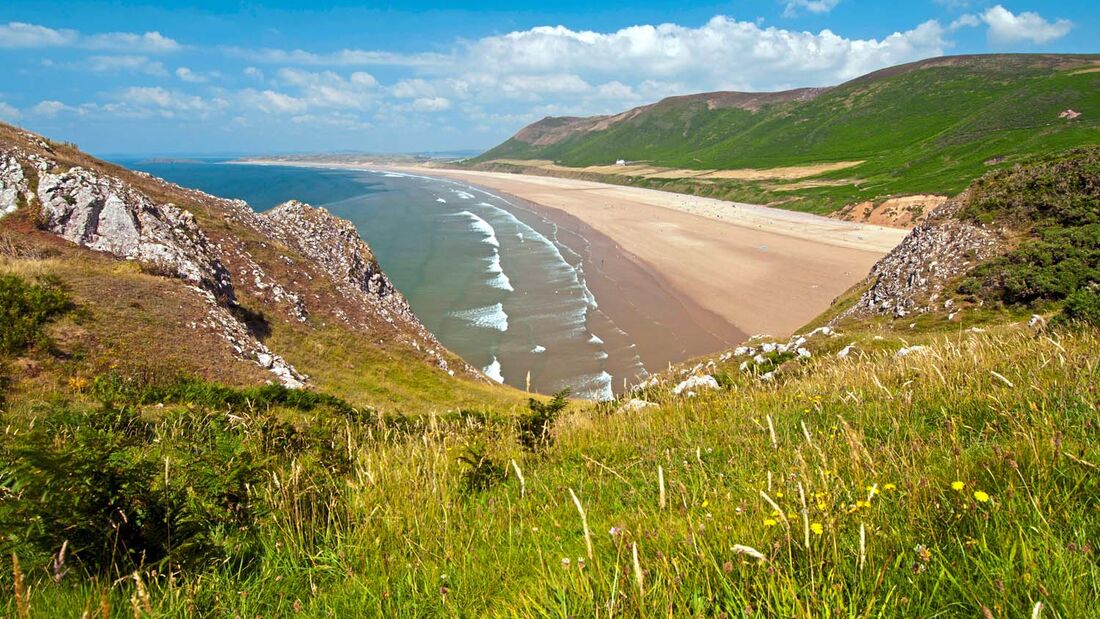Einer der schönsten und beliebtesten Surfstrände in Wales ist der über fünf Kilometer lange Sandstrand von Rhossili Bay.