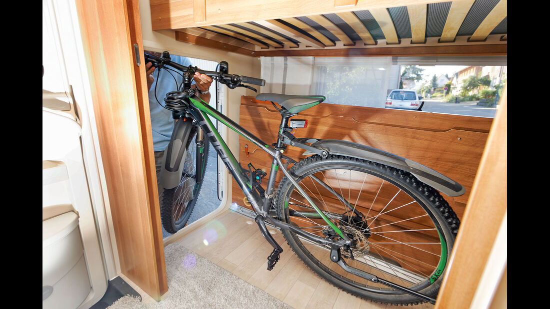 Matratze und Bettrahmen an Heckwand klappbar, schafft Platz für Fahrradgarage
