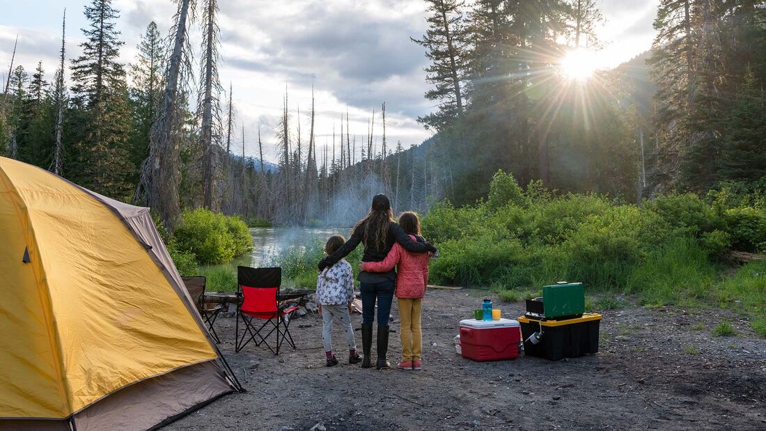 Mother and daughters bonding while camping in nature