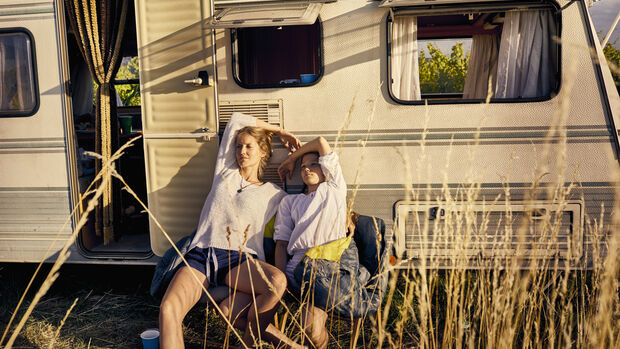 Mother with daughter relaxing at a caravan