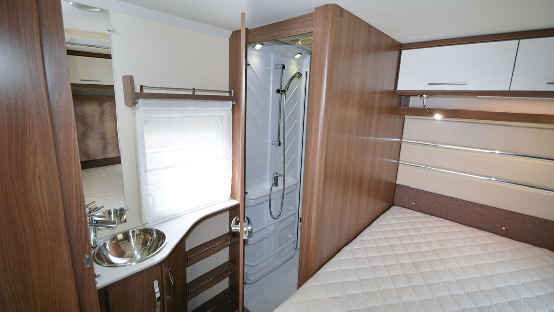 Parallel zum Bett erstreckt sich der Sanitärbereich mit Dusch- und Toilettenraum.