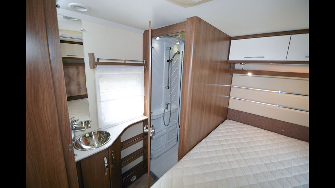 Parallel zum Bett erstreckt sich der Sanitärbereich mit Dusch- und Toilettenraum.